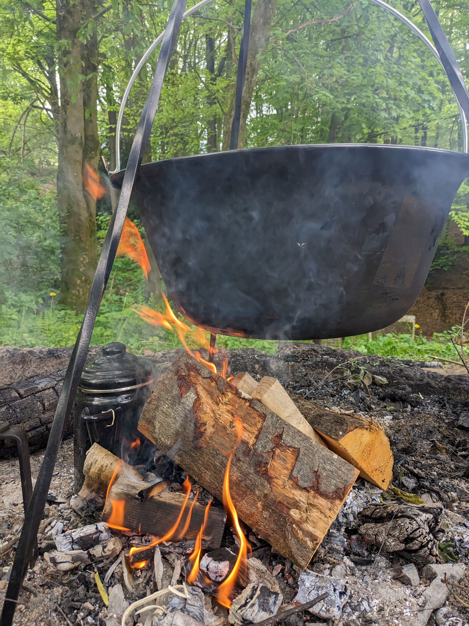 Emaille-Kessel über dem Lagerfeuer.